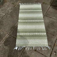 plastik og bomuld vævet svensk kludetæppe grønne nuancer og hvidt i mønster og striber.